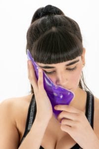 Woman holding an ice pack to her cheek