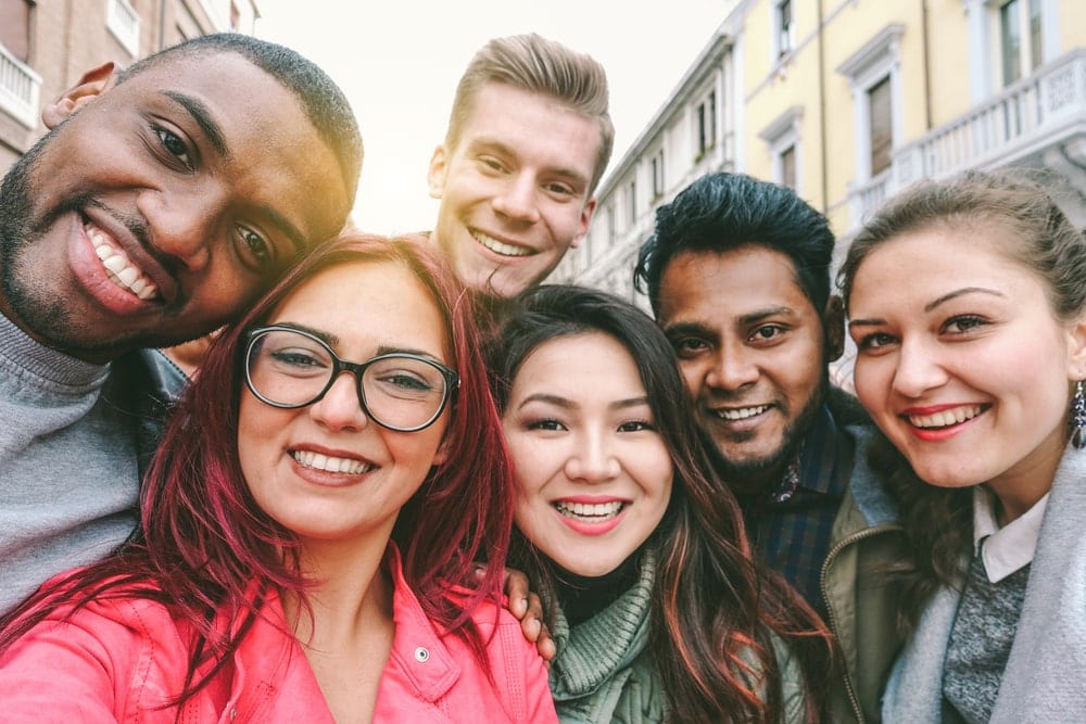 Group of people smiling and taking a selfie