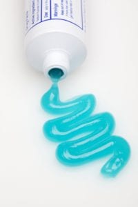 toothpaste being squeezed out of tube