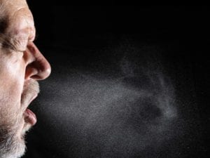 man exhaling airborne droplets